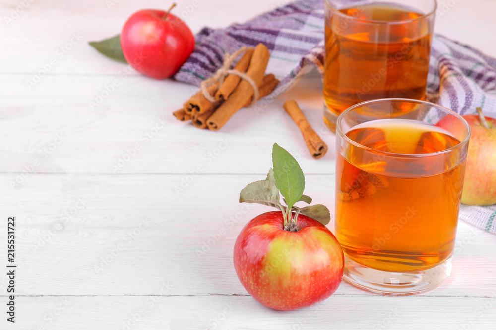 apple juice with fresh beautiful apples and cinnamon on a white wooden background apple juice with fresh beautiful apples and cinnamon on a white wooden background