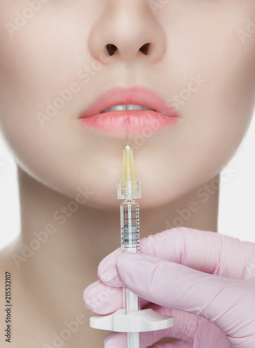 The cosmetologist makes injections of botulinum toxin in the lips of the patient. Cosmetology skin care. photo