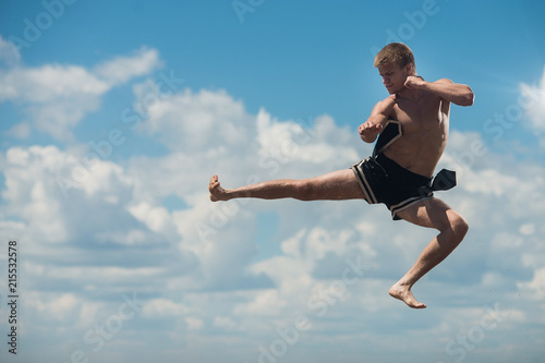 Man flying kick in sky background © Vladimir