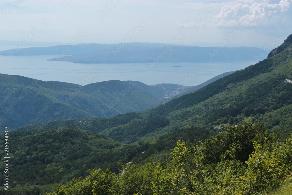 Panoramic view of the adriatic sea and mountains in Croatia, Dalmatia. In the valley lies the town Senj. South Europe. Aerial view down from Velebit national park.