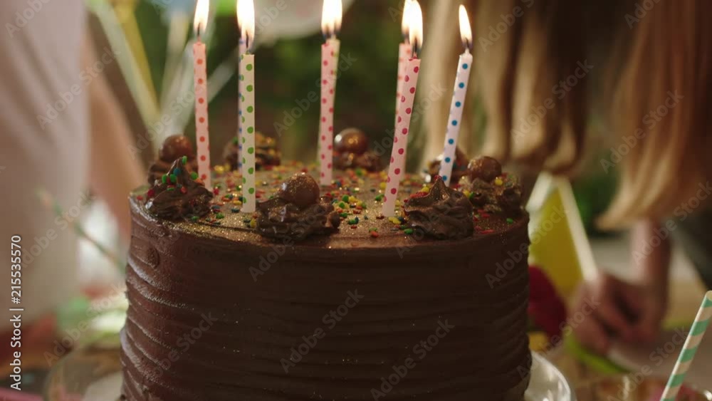 close up children birthday party girl blowing candles on delicious chocolate cake making wish kids enjoying happy celebration
