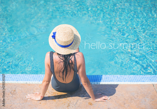 Beautiful girl in a black swimsuit near a blue pool-summer, sun, rest, inscription hello summer.