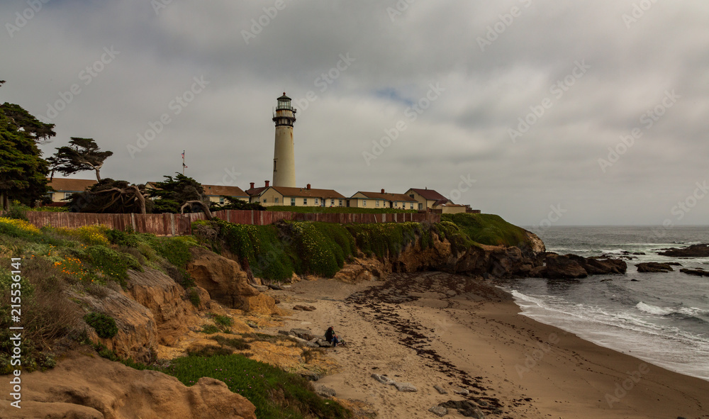 Pigeon Point Light Station on cloudy day with couple sitting on beach