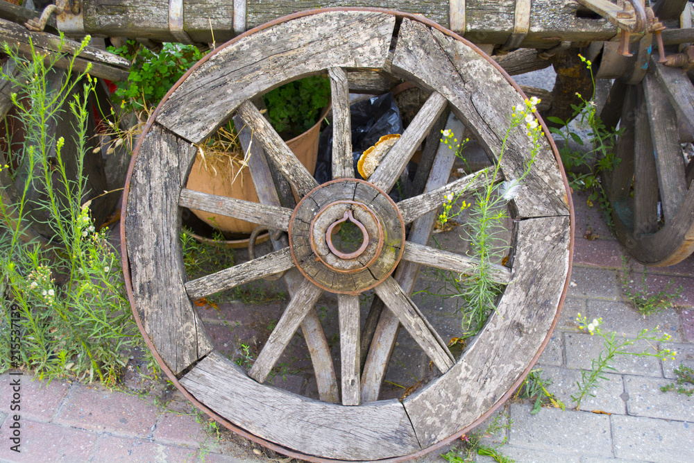 old wheel is leaning against the old horse car