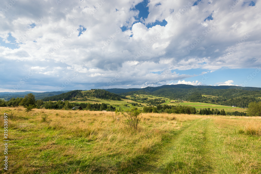 Rural scenery. Fields, mountains and clouds on the sky. Pieniny National Park. Malopolska, Poland.