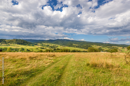 Rural scenery. Fields, mountains and clouds on the sky. Pieniny National Park. Malopolska, Poland.