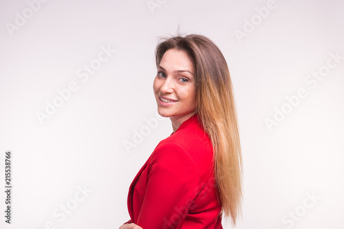 Portrait of young woman in a red suit posing on white background with copy space