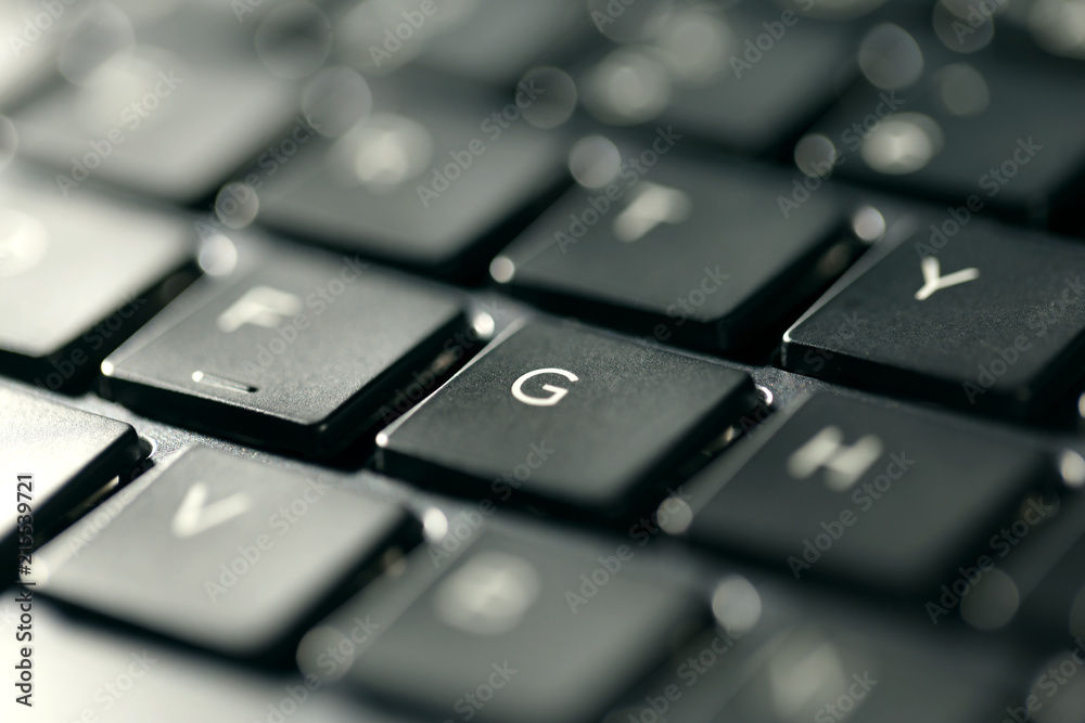 Macro view of black laptop keyboard buttons against back light Macro view of black laptop keyboard buttons against back light