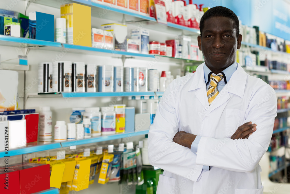 man pharmacist standing in interior of pharmacy