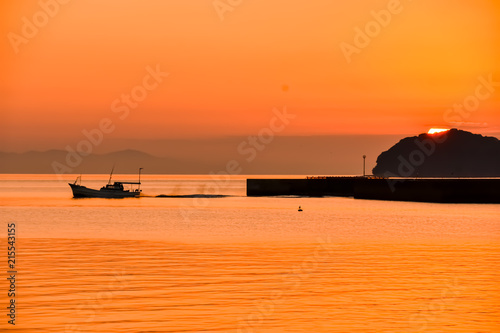 美しい夕焼けの海 　絶景の夕日と漁船風景写真 　日本 津奈木町海岸　Beautiful sunset sea Picturesque sunset and fishing boat scenery photo Japan Tsunagi Town Coast photo