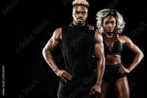 Fitness couple of athletes posing on black background, healthy lifestyle body care. Sport concept with copy space.