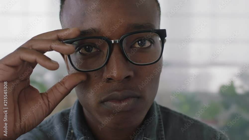 close up portrait of young african american business student intern man removes glasses looking serious at camera close up portrait of young african american business student intern man removes glasses looking serious at camera