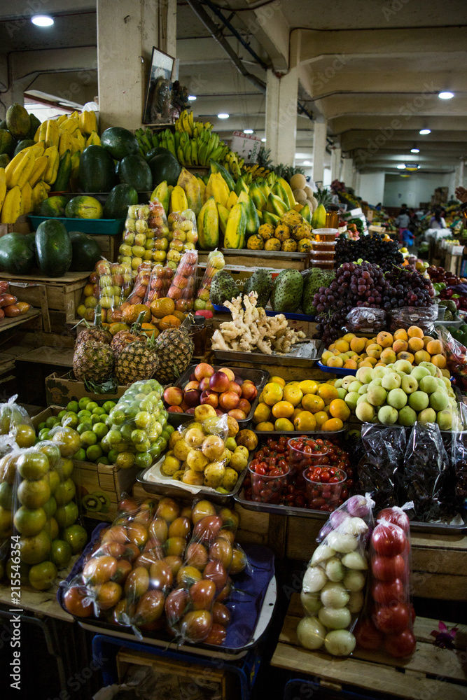 Fresh, organic fruit piled up in bowls in a packed street market stall in Ecuador