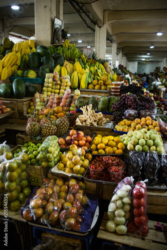 Fresh, organic fruit piled up in bowls in a packed street market stall in Ecuador