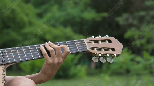 Hands of a girl on a guitar fretboard. photo