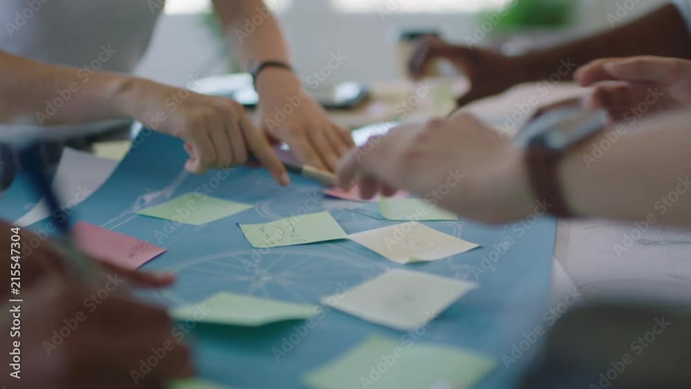 close up young diverse team group of people brainstorming ideas designing bicycle using blueprint discussing solutions in modern workspace