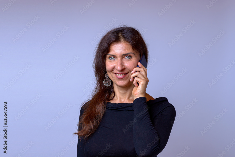 Friendly mature woman talking on mobile phone Friendly mature woman talking on mobile phone