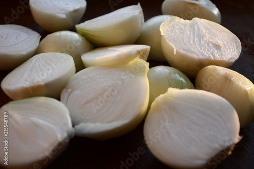 white onion cut in half on a wooden plate