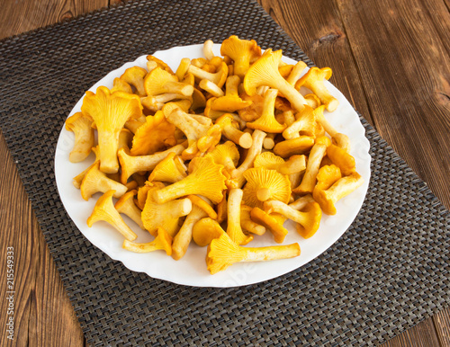 Plate with mushrooms chanterelles on a wooden background, boletus
