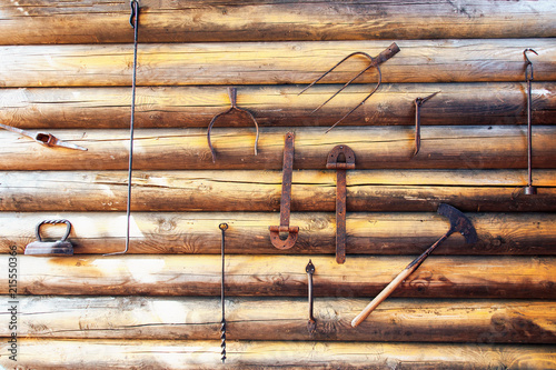 historical tools hanging on a wooden wall photo