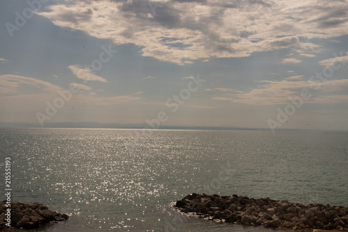 The sea of Bibione, Veneto, Italy, with a dazzling reflection and clouds in the sky covering the sun's rays