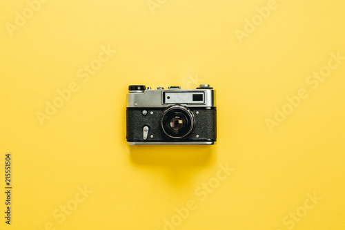 Vintage retro camera isolated on yellow background. Flat lay, top view.