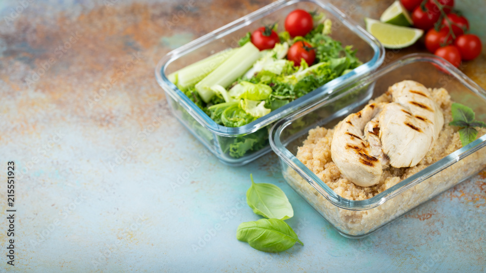 Healthy meal prep containers with quinoa, chicken breast and green salad overhead shot with copy space