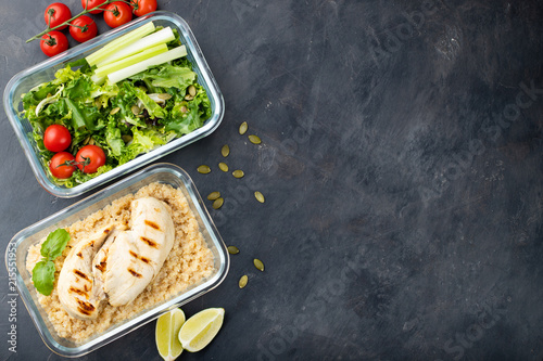 Healthy meal prep containers with quinoa, chicken breast and green salad overhead shot with copy space. Top view. Flat lay photo