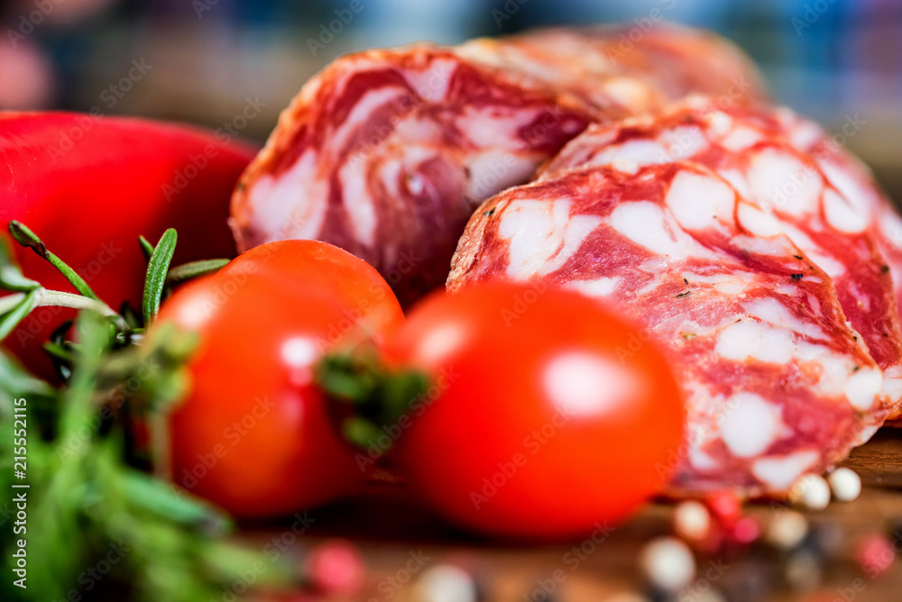 Tasty salami with tomatoes and peppercorn close Tasty salami with tomatoes and peppercorn close