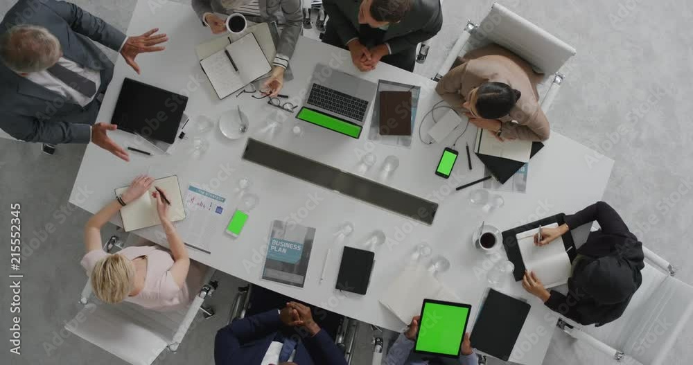 multi ethnic business people brainstorming innovative ideas viewing green screen using mobile computer technology in boardroom meeting overhead