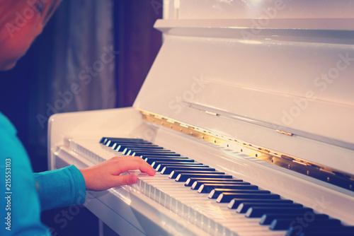 Hands on the white Keys of the Piano Playing a Melody. Women's Hands on the Keyboard of the Piano, Playing the Notes Melody. Hands of young Girl, Music on the Piano photo