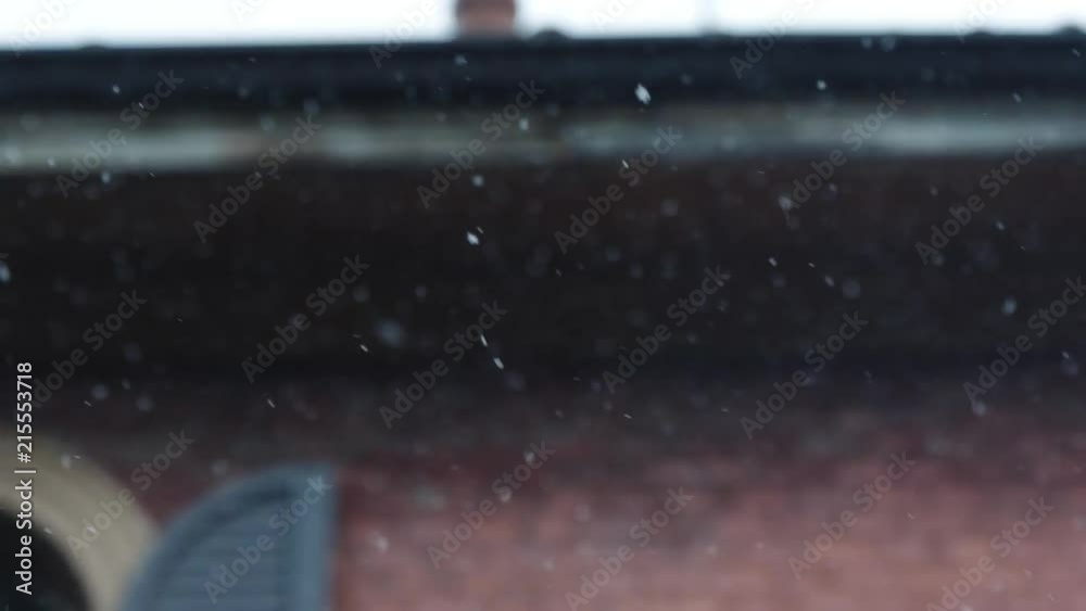 Snowflakes Falling Down Slowly with a Old Red-Brick House in the Background with Open Blinds Snowflakes Falling Down Slowly with a Old Red-Brick House in the Background with Open Blinds