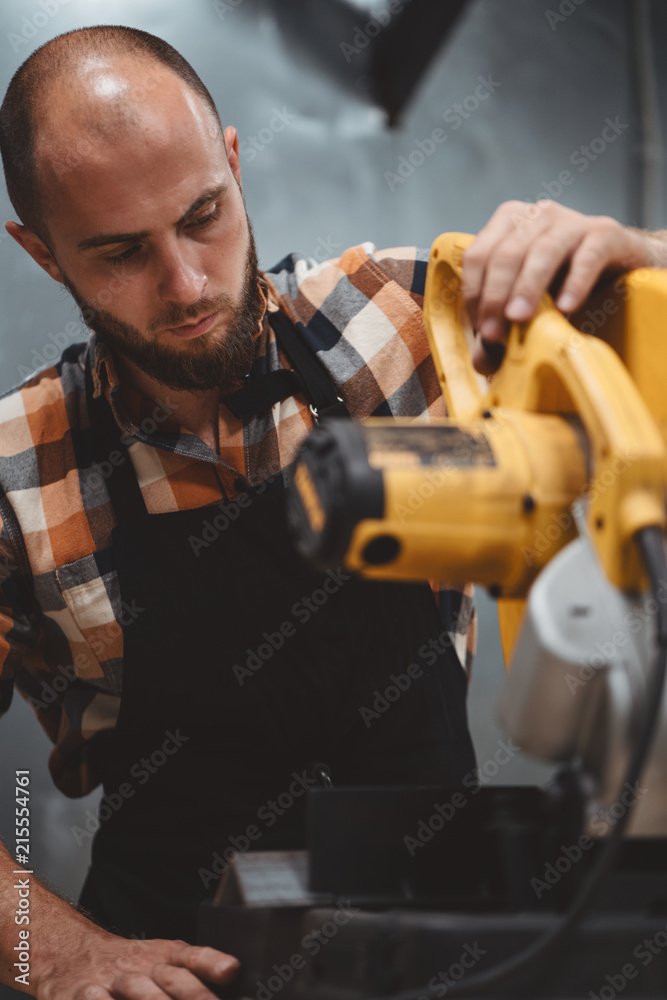 Service mechanic working on electrical grinding machine in service station. Servicing of machines. Workflow at the factory. Vertical Service mechanic working on electrical grinding machine in service station. Servicing of machines. Workflow at the factory. Vertical