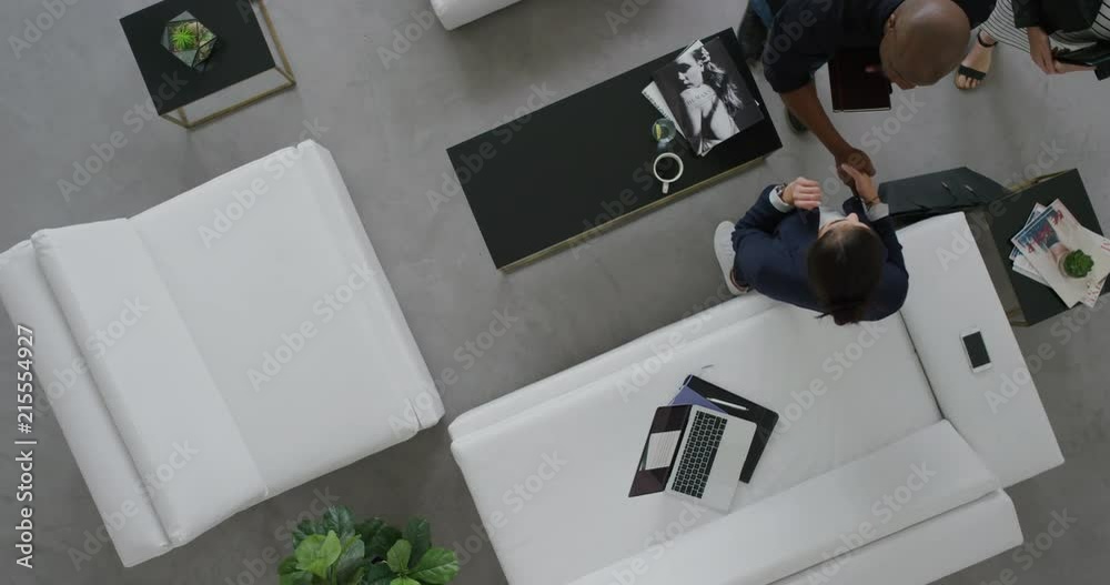 multi ethnic business people meeting shaking hands model agent sharing advertising ideas showing clients fashion marketing project in modern office lobby top view