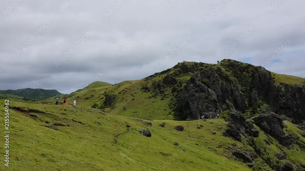 Tourists walking on a mountain sightseeing. Shot in Batanes, Philippines. Tourists walking on a mountain sightseeing. Shot in Batanes, Philippines.