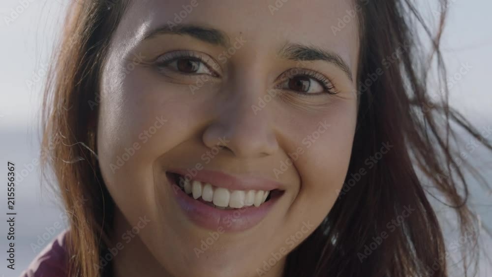 close up portrait of young pretty hispanic woman smiling looking up at camera enjoying warm sunny day close up portrait of young pretty hispanic woman smiling looking up at camera enjoying warm sunny day
