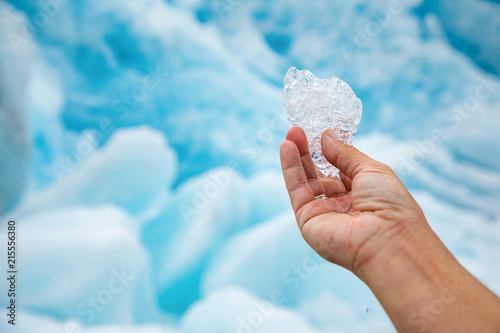 Pure transparent piece of ice in hand with the Svartisen glacier in Norway