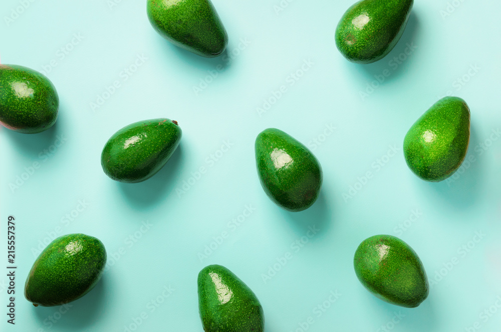 Avocado pattern on blue background. Top view. Banner. Pop art design, creative summer food concept. Green avocadoes, minimal flat lay style. Avocado pattern on blue background. Top view. Banner. Pop art design, creative summer food concept. Green avocadoes, minimal flat lay style.