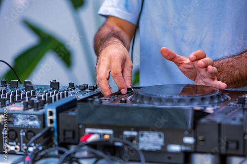 Photo of adult dj working with his equipment. Close up shoot