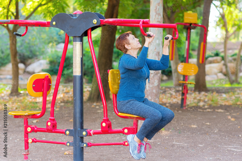 Senior 60 70 year old age woman working out on the sports public