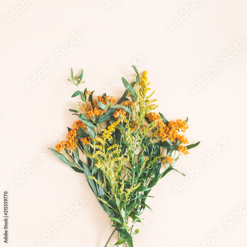 Bouquet made of fresh flowers on pastel beige background. Autumn, fall concept. Flat lay, top view, square