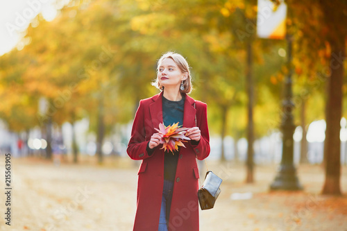 Young woman with bunch of colorful autumn leaves