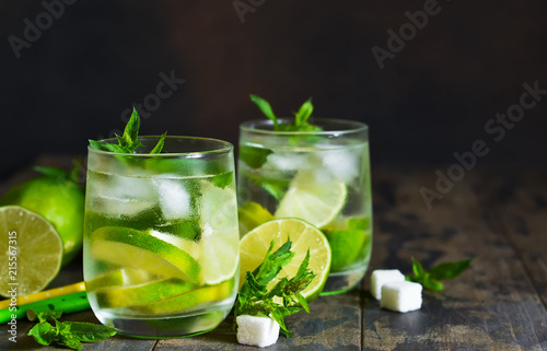 Cold alcohol mahito with mint and lime on a dark background. Summer drink.