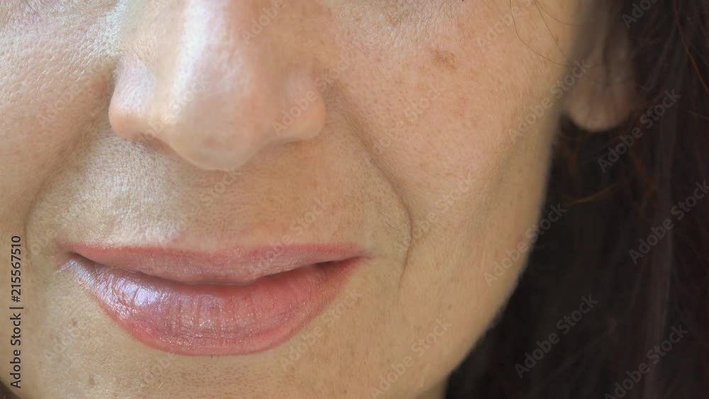 mature woman smiling and lapping shimmering lipstick on cracked lips with tongue, showing mature skin with aging spots, neo, wrinkles and moustaches mature woman smiling and lapping shimmering lipstick on cracked lips with tongue, showing mature skin with aging spots, neo, wrinkles and moustaches