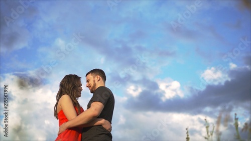 Photos Young happy couple kissing in nature against the setting sun at sunset