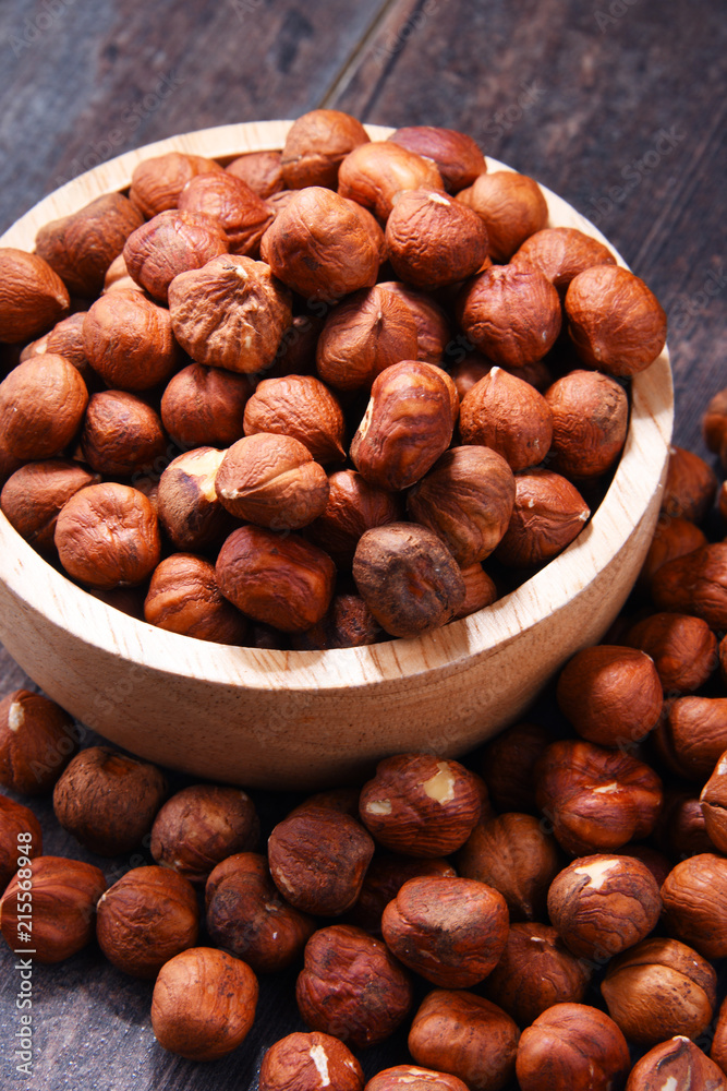 Bowl with hazelnuts on wooden table. Bowl with hazelnuts on wooden table.