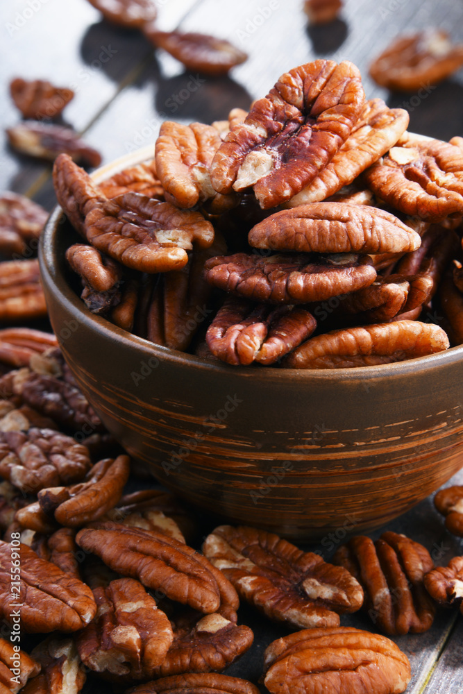 Bowl with pecan nuts on wooden table. Bowl with pecan nuts on wooden table.