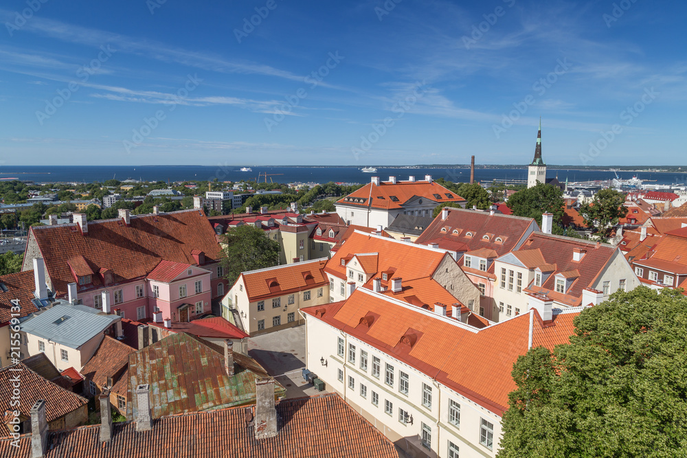 Old buildings and St. Olaf's (or Olav's) church's tower at the Old Town in Tallinn, Estonia, viewed from above on a sunny day in the summer.