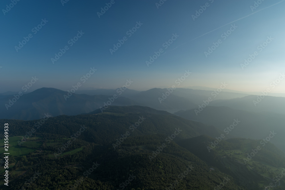 Sunbath of mountains with forests under a blue sky panorama at Catalonia, Spain