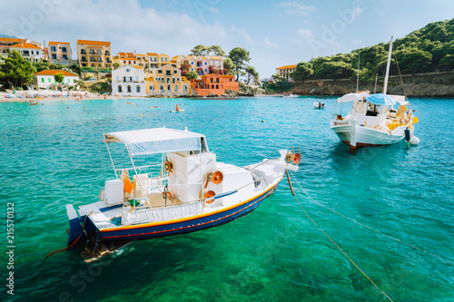 Assos village on Kefalonia island, Greece. White boats in the emerald rippled sea water bay
